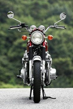 a motorcycle parked on the side of a road with trees in the backgroud