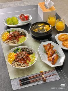 a table topped with plates and bowls filled with food