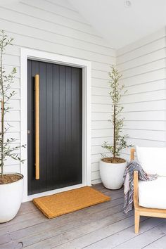 the front porch is decorated with plants and potted trees