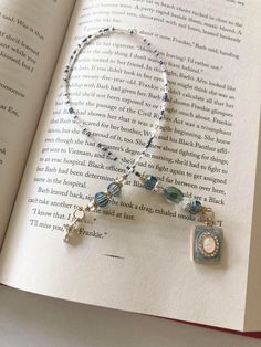 an open book with a necklace on it