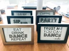 four framed signs with words on them sitting on a table