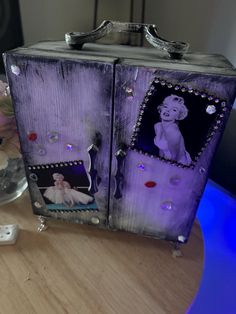 an old fashion jewelry box with pictures on the front and sides, sitting on a table