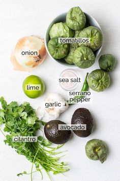 the ingredients for an avocado salad laid out on a white surface