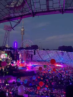 an aerial view of a concert venue at night with lights and balloons in the air