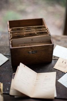 an old wooden box filled with lots of cards and papers on top of a table