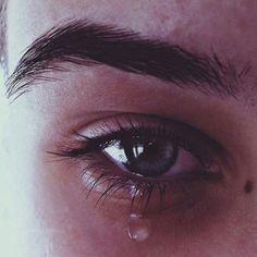 a close up of a person's eye with water dripping from the bottom of it