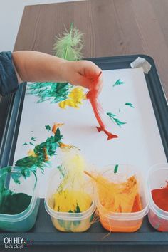 a young child is painting on a tray