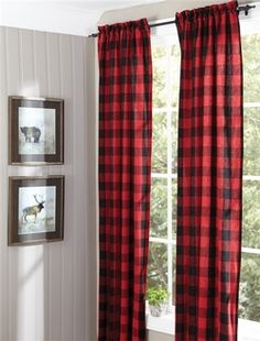 a red and black plaid curtain hanging on a wall next to a window with two pictures