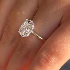 a woman's hand with a diamond ring on top of her finger and an engagement band