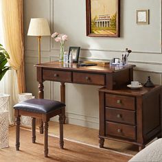 a bedroom with a desk and chair next to a painting on the wall above it