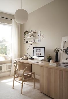 a desk with a computer on top of it next to a window