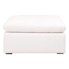 a white ottoman with pillows on it