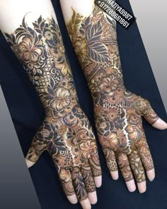 two hands with henna tattoos on them, one is brown and the other is black