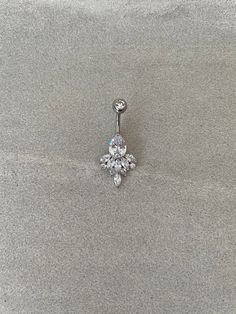 an image of a jeweled belly ring on the sand