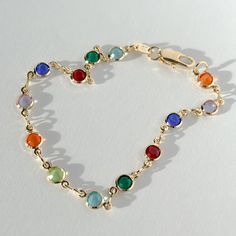 Compliment your bracelet stack with this gorgeous circular jewel-toned glass + gold filled bracelet! Made with 18K 1/30 gold-filled chain and pastel-colored glass components, this is a bracelet that's easily stacked, or worn on its own. 18K 1/30 gold-filled bracelet 7 in. length chain Jewel-toned glass components Care instructions: With the proper care, gold-filled jewelry can last a very long time! Here are some handy tips for making sure that your jewelry shines as long as possible: While wate Gold Glass Round Bracelets, Gold Glass Beaded Bracelets, Gold Glass Bracelets, A Bracelet, Gold Filled Jewelry, Gold Filled Chain, Jewel Tones, Bracelet Stack, Colored Glass