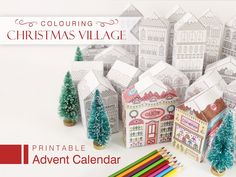 a group of paper houses with colored pencils in front of them and the words, coloring christmas village printable