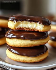 chocolate covered donuts stacked on top of each other with white frosting in the middle