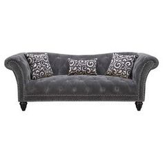 a gray couch with two pillows on it and some black trim around the armrests