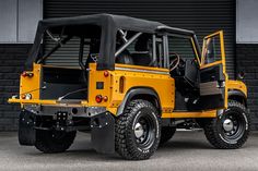 a yellow jeep parked in front of a garage