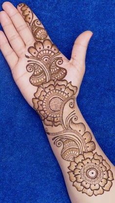 the hand is decorated with henna and flowers on it's palm, as well as an intricate design