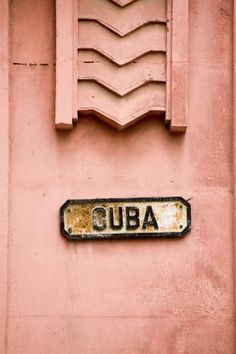 a sign on the side of a building that says cuba written in gold and black