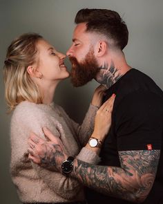 a man and woman with tattoos kissing each other