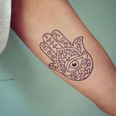 a hamsa tattoo on the arm with an eye in it's centerpiece