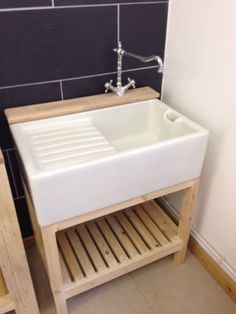 a white sink sitting on top of a wooden shelf