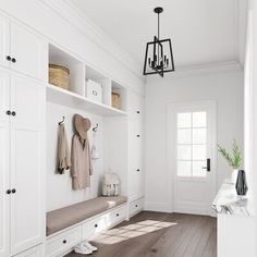 a room with white walls and wooden floors has a bench, coat rack, and two coats hanging on the wall