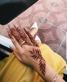 a woman's hand with henna on it and her hands painted in brown