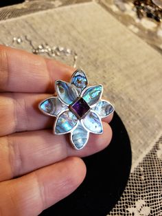 "Super HIGH QUALITY Everything! All Sterling Silver in a flower shape; Petals are all made of inlaid ABALONE (specifically from New Zealand and called Paua Shell - very intense colors); Center is a 7x7mm Sugarloaf cut AMETHYST. **THIS PIECE IS BOTH A PENDANT AND A PIN OR BROOCH** Measures 1.25\" each direction. I am including an 18\" Sterling Silver chain too. Hallmarked SAJEN 925 By the renowned designers RICHARD & MARIANNA JACOBS, the OFFERINGS line by SAJEN. Made in Bali. Contact me with Sterling Silver Jewelry With Purple Flower Charm, Purple Sterling Silver Flower-shaped Jewelry, Purple Sterling Silver Jewelry With Flower Charm, Purple Flower-shaped Nickel-free Jewelry, Amethyst Flower Pendant Jewelry Gift, Amethyst Flower Pendant Jewelry For Gift, Purple Nickel-free Flower-shaped Jewelry, Purple Nickel-free Flower Jewelry, Purple Flower-shaped Sterling Silver Jewelry