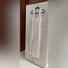 a white dress hanging on a hanger in front of a door