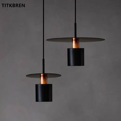 three black and copper lights hanging from the ceiling