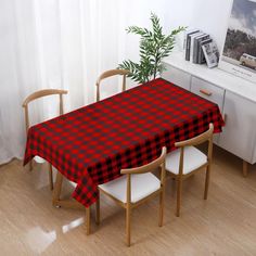 a red and black checkered tablecloth on a dining room table with two chairs