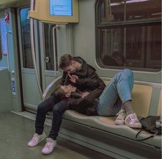 two people sitting on a subway bench next to each other