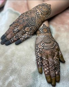 two hands with henna tattoos on them