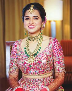 a woman in a red and gold bridal outfit