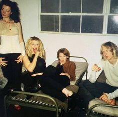 three women sitting on top of a bed next to each other in a living room