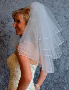 a woman in a wedding dress with a veil on her head