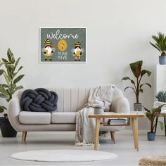 a living room with a white couch and potted plants on the floor, next to a welcome sign