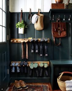 an entryway with shoes and umbrellas hanging on the wall next to a bench