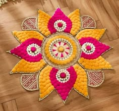 a colorful flower design on the floor with beaded beads and threads around it