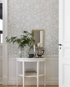 a white table sitting in front of a wall with a mirror on it's side