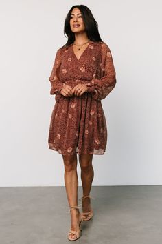 The Anne Short Dress in lightweight chiffon boasts a deep rust color with a delicate floral print. It features a surplice neckline, puff sleeves with buttoned cuffs, subtle ruffles, and a pleated, gathered waist with a smocked back for a stylish, flowy look. Short Flowy Skirt, Cocktail Jumpsuit, Destination Dress, Surplice Neckline, Rust Dress, Chiffon Material, Romper Outfit, Velvet Fashion, Color Background