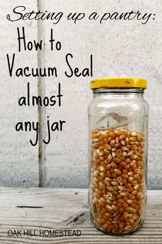 a jar filled with peanuts sitting on top of a wooden table next to a white wall