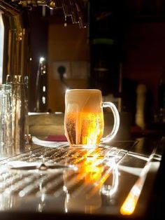 there is a mug that is sitting on the counter next to some glasses and bottles