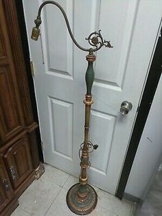 an antique floor lamp stands in front of a door