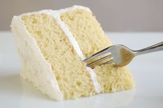 a piece of cake with white frosting and a fork sticking out of the side