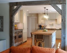 an open kitchen and living room area with couches in front of the stove top oven