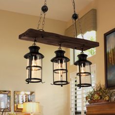 three lights hanging from a wooden beam in a living room